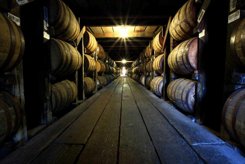 Image of stacked bourbon barrels in a distillery